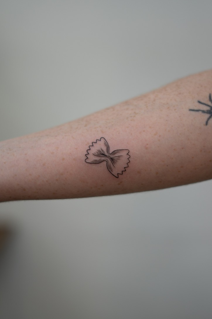 Small bow tattoo on forearm