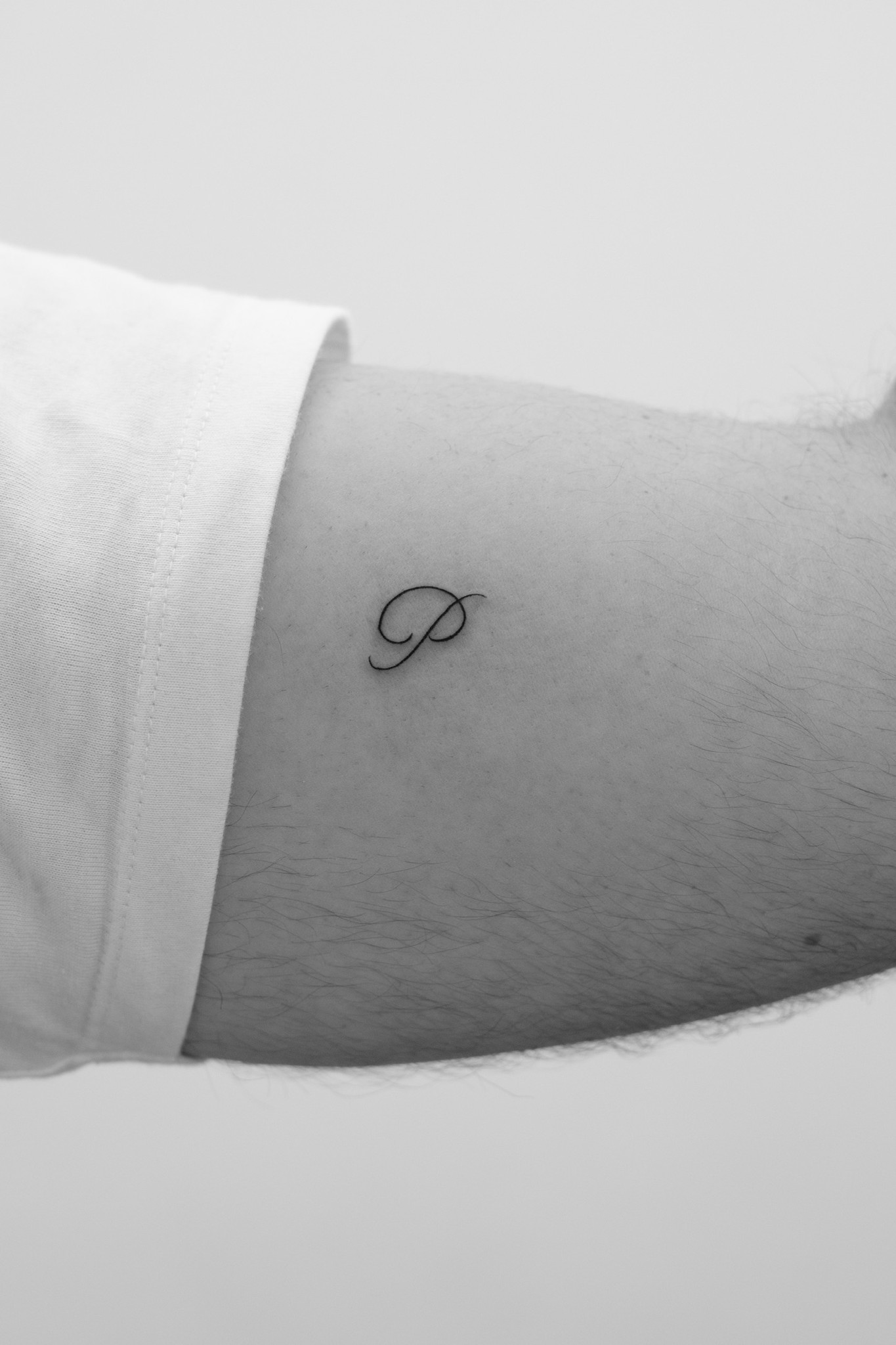 Single-letter tattoo in black and white